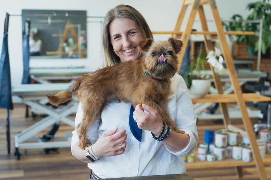 Nicole hält im Hundesalon in Innsbruck einen Brüsseler Griffon namens Miguelito auf den Händen.